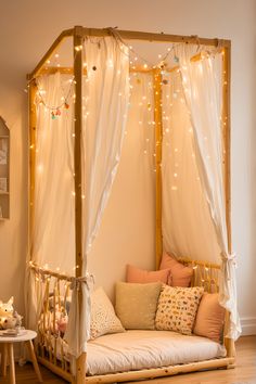 a canopy bed with white curtains and lights on the ceiling is in a child's room