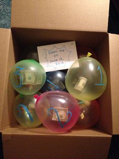 a box with some balloons in it and a sign on the top that says open one dollar