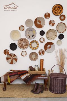 there are many plates on the wall and one has a basket in front of it