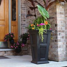 a large planter with flowers in it sitting on the front step of a house