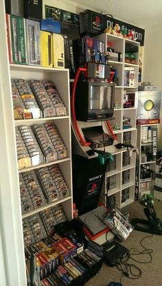 a room filled with lots of video game equipment and games on shelves next to each other