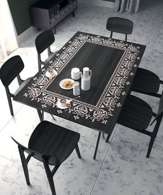 a table with four chairs around it and a rug on the floor next to it