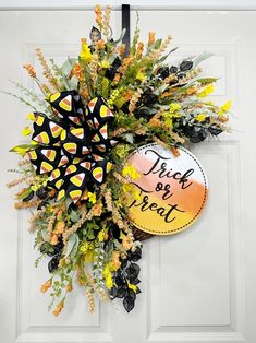 a wreath is hanging on the front door with a trick or treat sign attached to it