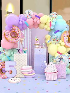 a birthday party with balloons, cake and cupcakes