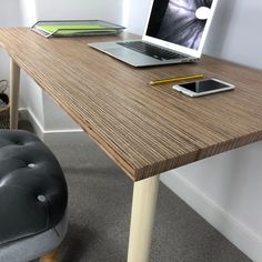 an open laptop computer sitting on top of a wooden desk next to a black chair