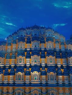 a very tall building with lots of windows on it's sides and balconies