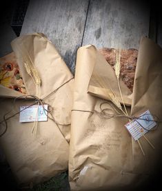 two brown paper bags tied with twine and some wheat on top of each bag