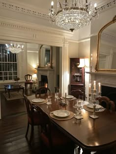 the dining room table is set with place settings for six people and has candles on it