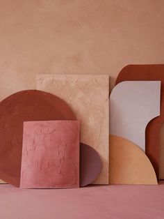 an assortment of different shapes and sizes on a pink tablecloth with a beige wall in the background