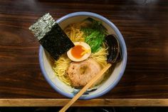 a bowl of ramen with chopsticks and an egg