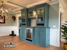 an empty kitchen with blue cabinets and wood flooring, along with a potted plant