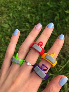 a woman's hand with four rings on it and the letters love spelled in different colors