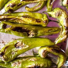 some green peppers sitting on top of a pan covered in brown sauce and seasoning