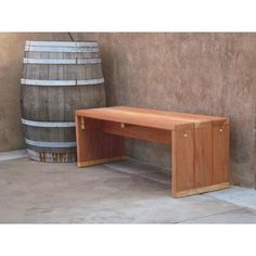 a wooden bench sitting next to a barrel