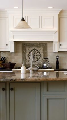 a large kitchen with white cabinets and marble counter tops, along with an island in the middle