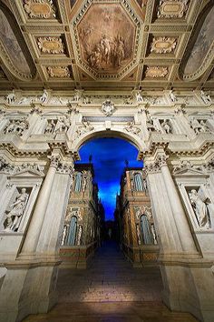 an ornately decorated building with blue light coming from the ceiling and stairs leading up to it