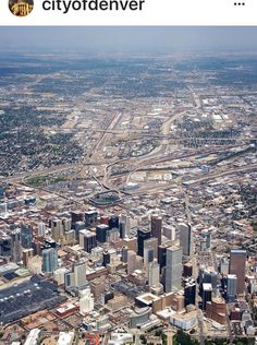 an aerial view of a city with lots of tall buildings and roads in the distance