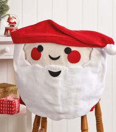 a santa clause pillow sitting on top of a wooden stool