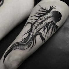 a black and white photo of two people with tattoos on their legs, one is holding a fish