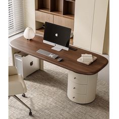 an office desk with a computer on it in front of a bookcase and window