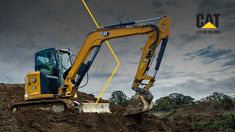 an excavator sits on top of a pile of dirt in front of a cloudy sky