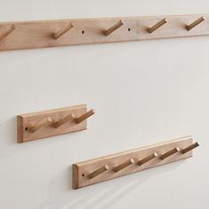 three wooden pegs are hanging on the wall