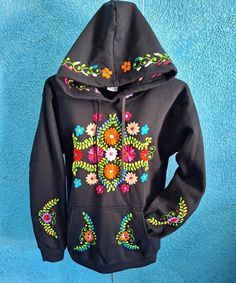 This colorful sweatshirt is perfect to keep warm, comfortable, and stylish during the cold winter months. They have hand embroidered details on both sleeves, front center, and on the hoodie. This sweatshirt is hand embroidered by Mexican Artisans and each can take up to a week for one person to finish!  Each sweater is 50% cotton/50% polyester.  Please choose a size in the drop down menu. You will receive a sweatshirt with the same pattern as the picture, however, the colors may differ as they a Casual Multicolor Embroidered Sweater, Embroidered Hooded Sweatshirt For Winter, Hooded Embroidered Sweatshirt For Winter, Hooded Winter Sweatshirt With Embroidered Graphics, Winter Hooded Sweatshirt With Embroidered Graphics, Winter Sweater With Embroidered Graphics, Black Embroidered Hooded Hoodie, Winter Long Sleeve Sweater With Embroidered Graphics, Cotton Hoodie With Embroidered Graphics