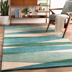 a living room area with a chair, rug and book shelf on the floor in front of it