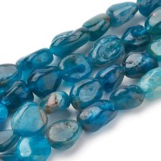 blue glass beads are lined up on a white surface