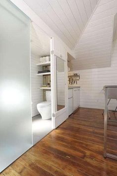 a bathroom with white walls and wooden floors