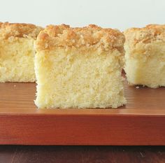 three pieces of cake sitting on top of a wooden cutting board