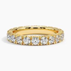 a yellow gold band with rows of round diamonds on the inside and outside of it