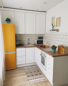 a kitchen with white cabinets and yellow refrigerator freezer next to a counter top oven