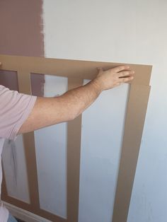 a man is painting the wall with white paint