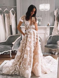 a woman standing in front of a mirror wearing a wedding dress and looking at her cell phone