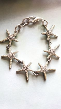 a silver bracelet with five starfish charms