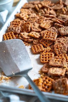 a pan full of waffles with a spatula on the side and other food items