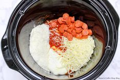 the ingredients are in the slow cooker to make this meal, including cheese and carrots