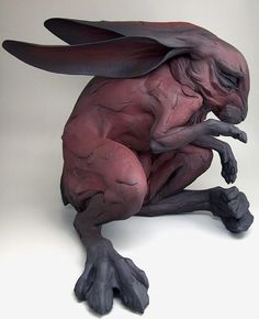 a sculpture of a demon sitting on its hind legs