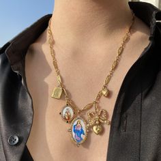 Bow and Book Necklace, 18K yellow gold (750/1000). Chain: 50.8cm length. • Large hand-painted enamel “The Immaculate Conception” medal. Set with 0.28 carats of white diamonds and 0.52 carats of yellow sapphires. Measurements 25mm width, 35mm length. • Medium hand-painted enamel “Our Lady of Carmel” medal. Set with 0.36 carats of pink sapphires and 0.16 carats of black diamonds. Measurements 25mm width, 35mm length. • Vintage French mechanical art nouveau book charm. Measurements 10mm width, 15mm Lucky Charm Necklace, Book Necklace, Mechanical Art, Immaculate Conception, Vintage Pocket Watch, Lock Necklace, Pocket Watch Chain, Zodiac Pendant, Charm Necklaces