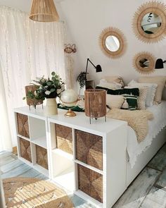 a bedroom with wicker baskets on the bed and round mirrors hanging from the ceiling