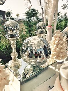 a table topped with lots of shiny disco balls