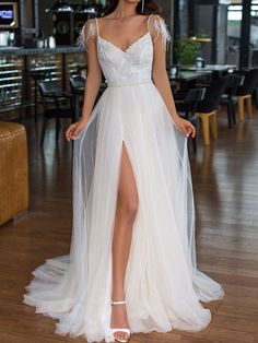 a woman in a white dress standing on a wooden floor