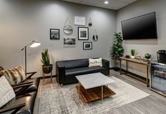 a living room filled with furniture and a flat screen tv mounted to the side of a wall