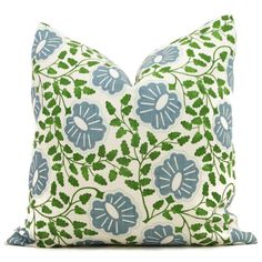 a blue and green floral pillow on a white background, with leaves in the middle