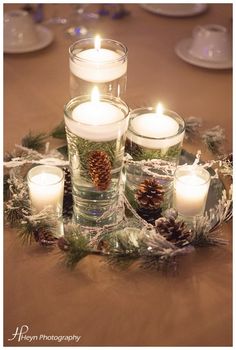 candles and pine cones are arranged on a table