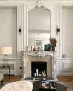 a living room filled with furniture and a fire place in front of a white fireplace