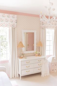 a white dresser sitting in a bedroom next to a window covered in pink and white curtains