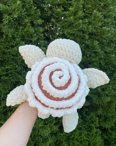 an overhead view of a hand holding a crocheted turtle