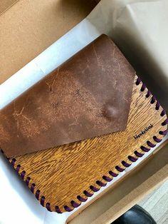 a brown leather wallet sitting on top of a box